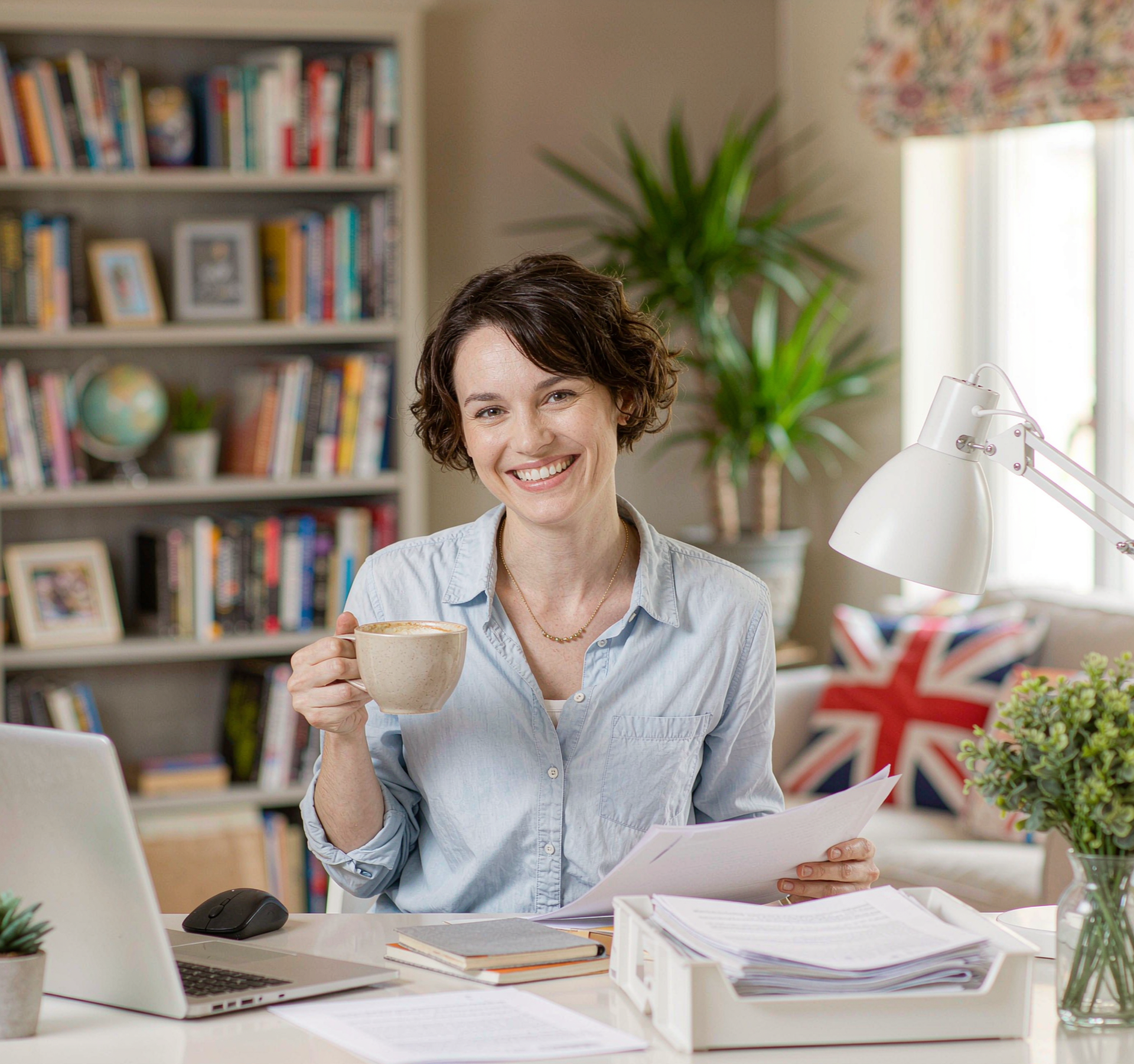A small business owner organising invoices and receipts at her home office desk