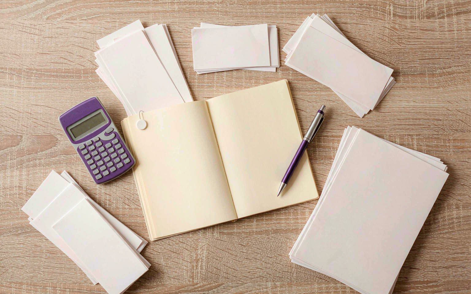 Organised bookkeeping flat lay with ledger, calculator and sorted receipts